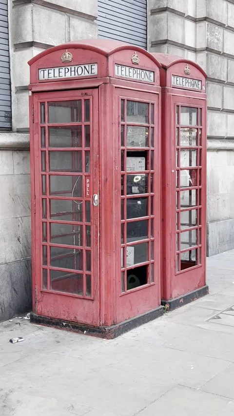 Iconic red British telephone boxes stand side by side on a London street Stock Footage 328104529