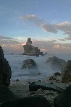 Iconic sea stack dominates the coastline at Buyutan Beach. Stock Photos