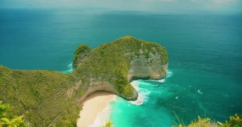 Iconic T-Rex shaped cliff at Kelingking Beach rises above the blue sea in Bali Stock-Footage 341295210