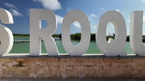 Iconic white Los Roques landmark sign with scenic ocean and mangroves background Stock Footage 332914625
