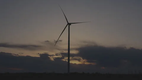 Iconic wind turbine against cloudy evening sky at sunset, 4K. Stock Footage 241545960