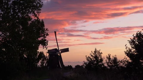 Iconic Windmill Silhouette Against a Dramatic Sunset Sky in the Netherlands Stock Footage 339546101