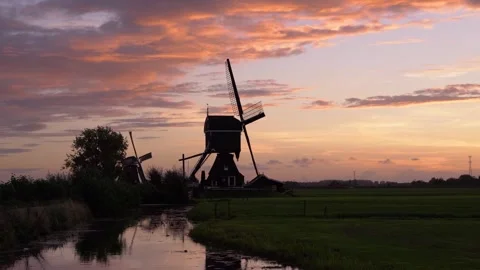 Iconic Windmill Silhouette Against a Dramatic Sunset Sky in the Netherlands Stock Footage 339546137