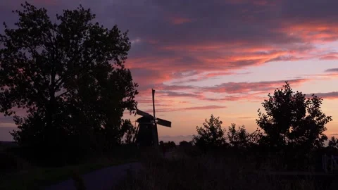 Iconic Windmill Silhouette Against a Dramatic Sunset Sky in the Netherlands Stock Footage 339546343