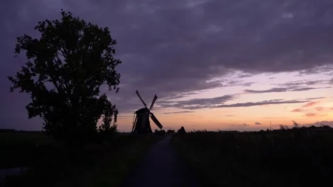 Iconic Windmill Silhouette Against a Dramatic Sunset Sky in the Netherlands Stock Footage 339546519