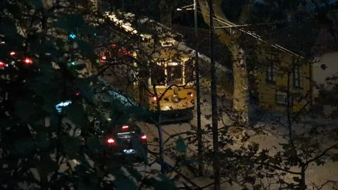 Iconic yellow tram passing through a street in Oporto at night with car traffic Video stock 337807786