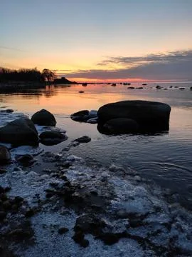 Icy bay at sunset Stock Photos