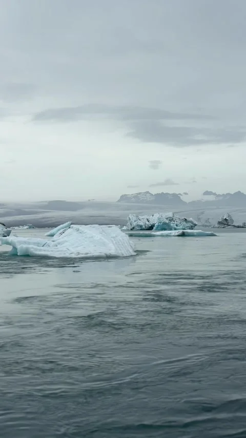 Icy giants float in the still waters of Jökulsárlón Glacier Lagoon, with Vatnajö 스톡 동영상 312232827