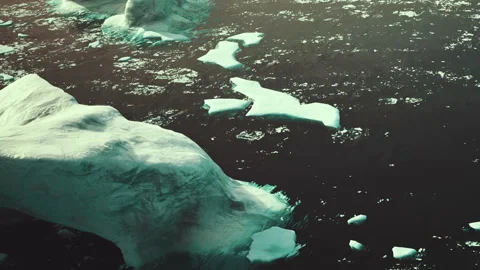 Icy landscape with floating ice pieces in dark water during daytime Stock Footage 339878080