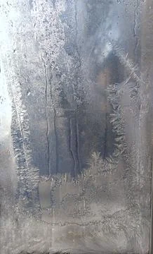 Icy patterns on the window glass in the winter. Stock Photos