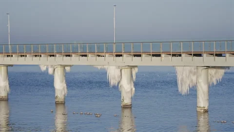 Icy Pier Columns With Long Icicles Over Sea Video stock 327457958
