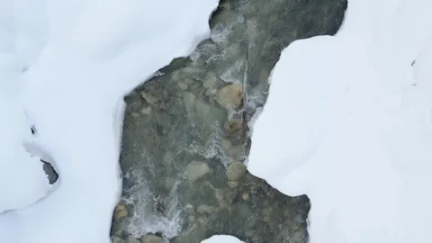 Icy river flowing between snow covered banks with abstract ice shapes and c.. Stock Footage 341267592