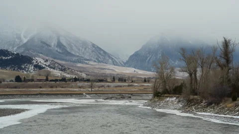 Icy River flowing out of Cloud Shrouded Mountains Stock Footage 327692529