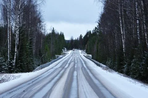 Icy road through a forest Stock Photos