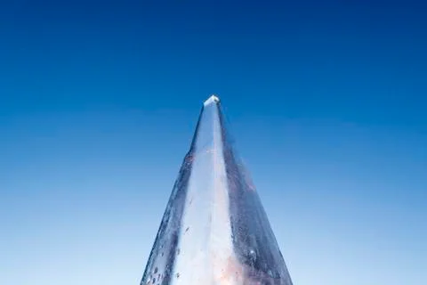 Icy triangular top on a blue sky background. Close-up. The concept of global  Stock Photos