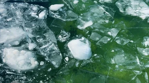 Icy water texture background. Broken ice pieces floating on green water.  Stock Footage 328296145