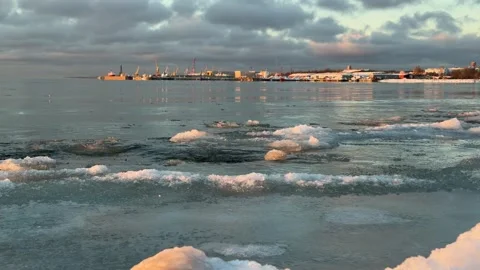 Icy winter sea with floating ice near the shore at sunset Stock Footage 328611255