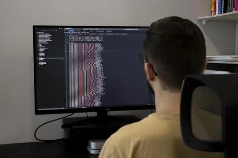IDE programming. A male freelancer writes a program at the computer javascrip 스톡 사진
