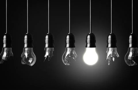 Idea concept with broken bulbs and one glowing bulb Stock Photos