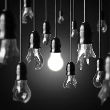 Idea concept with broken bulbs and one glowing bulb Stock Photos