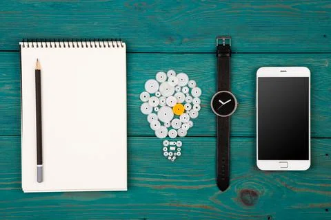 Idea concept - bulb sign, notepad, watch and phone on the desk Stock Photos