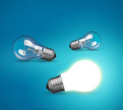 Idea concept with glowing light bulb on blue background Stock Photos