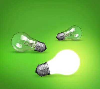 Idea concept with glowing light bulb on green background Stock Photos