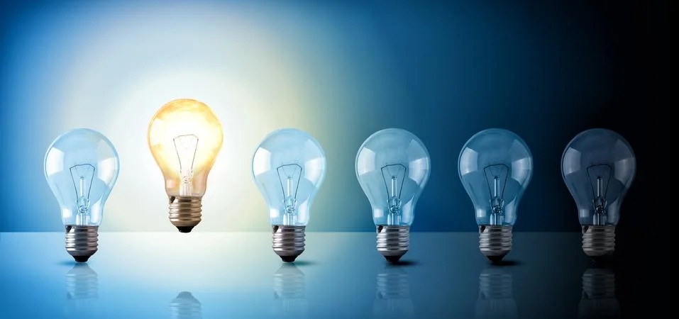 Idea concept with light bulbs sequence on blue background Stock Photos