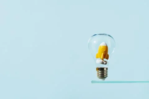 Idea inspiration with rocket light bulb on blue. Stock Photos