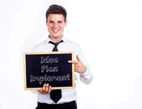 Idea - Plan - Implement - Young smiling businessman holding chalkboard with.. Stock Photos