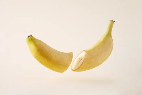 The idea of splitting into two and levitation. A cut banana levitates freely  Stock Photos