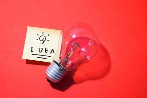 Idea on sticky notes and lightbulb. Isolated red background and copy space Stock-Fotos