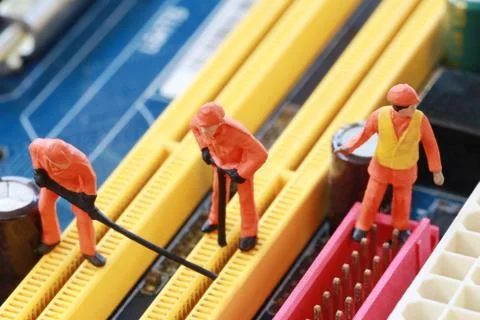 Idea of a worker is miners are digging for ore on computer mainboard. Stock Photos