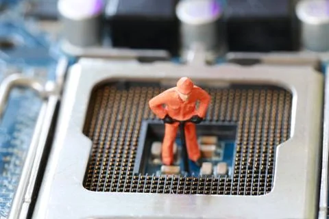 Idea of a worker is miners are digging for ore on computer mainboard. Foto stock