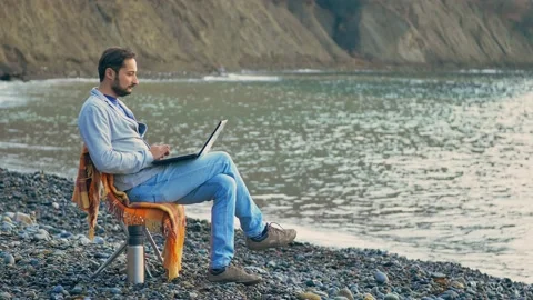 The idea of working remotely during a quarantine or pandemic. man sitting on a Stock Footage 150361600