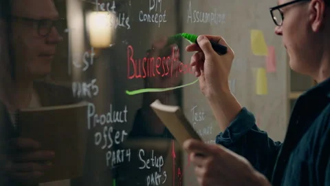 Ideas, Manager consultant deep writing note on glass wall in modern office s Stock Footage 242999249