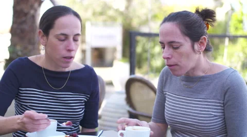 Identical twins sitting in a cafe, drinking coffee Stock Footage 58609686