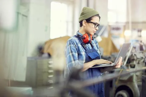 Identifying factory machine errors with laptop 写真素材