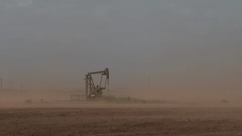 An idle pump jack in the Permian Basin as dust swirls around it, 4K. Stock Footage 101739475