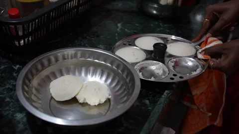 Idli removing from idli pot and collecting into plate, idli cooker Stock Footage 246693927