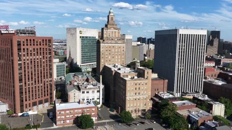 IDT logo marks glass office tower beside historic clock tower building, dense Stock Footage 340863264