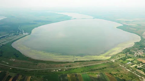 Idyllic aerial view of large lakes in foggy day near village Stock Footage 263306332