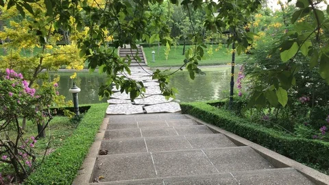 Idyllic Park Full of Blossoming Trees and Plants And Stone Bridge Crossing Pond Stock Footage 130099146