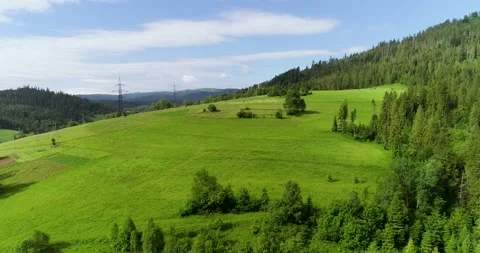 Idyllic rolling hills, high voltage steel power pylons in summer landscape Stock Footage 139262698