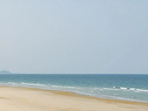 Idyllic Tranquil Sandy Beach with Calm Blue Ocean Waters and Expansive Clea.. Stock Photos
