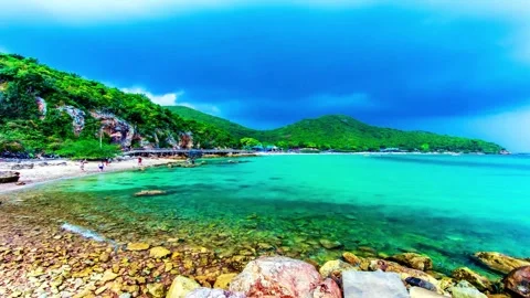 Idyllic Tropical Beach Scene with Clear Turquoise Waters and Lush Green Hills Stock-Footage 310244243