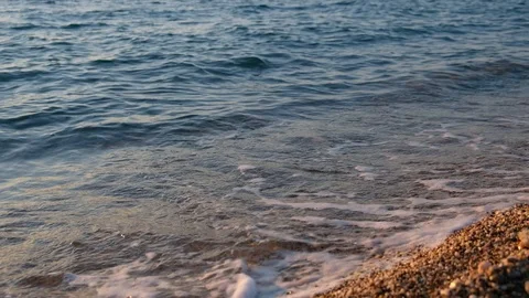 Idyllic view of the sea shore close-up. Foaming waves hit the sandy beach with Stock Footage 127046200