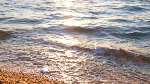 Idyllic view of the sea shore close-up. Sandy beach and small pebbles. Sun glare Stock Footage 127046921