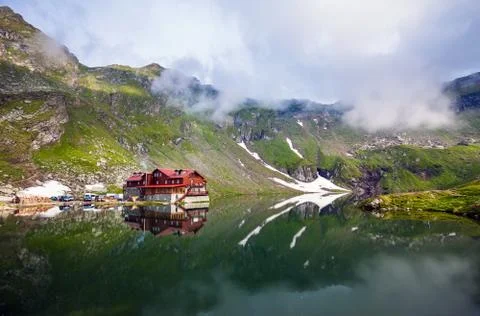 Idyllic view with typical cottage on Balea Lake shore in Fagaras Mountains Stock Photos