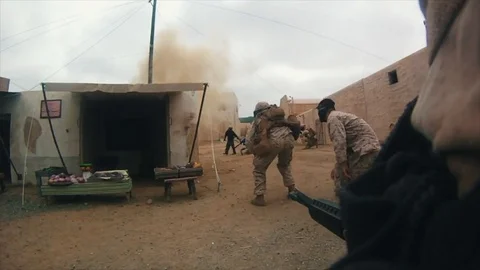 IED exploding in small town with military troops searching for the enemy Stock Footage